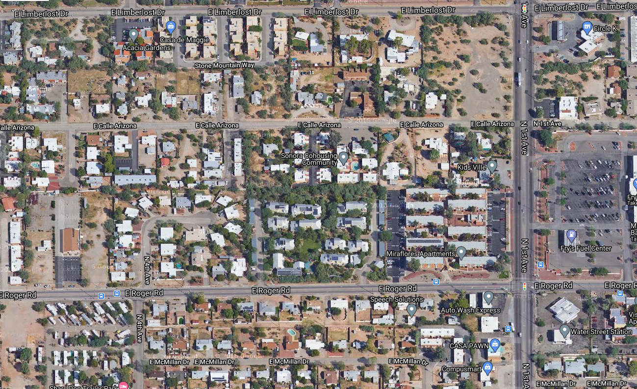 aerial view of urban neighborhood showing visibly green difference between barren, hard-scaped lots and permaculture-designed co-housing community site with permaculture design including rainwater and greywater harvesting and native food-bearing plantings