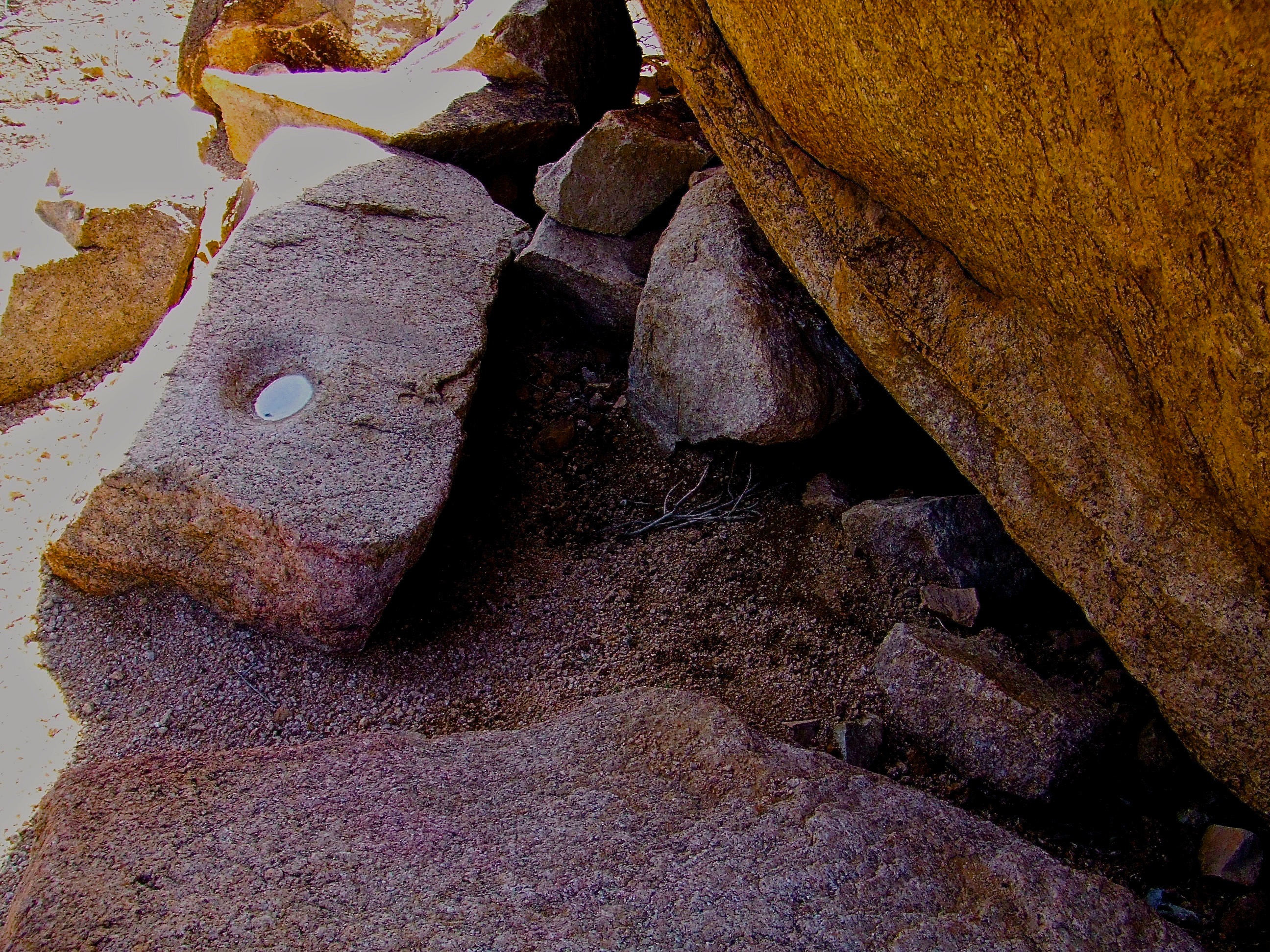 rain-filled ancient bedrock mortar for grinding mesquite pods with a stone pestle 